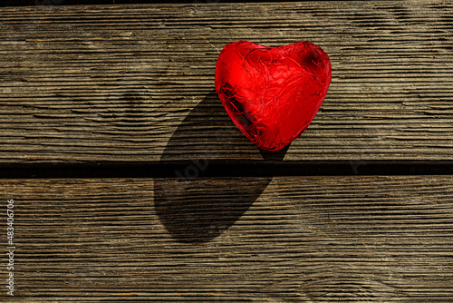 Rotes Schokoladenherz auf altem Holz