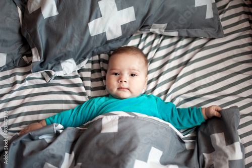Soft picture of a beautiful baby boy 1-3 months laying on bedding newborn photography