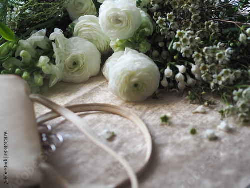 A white bridal handbag and white flowers