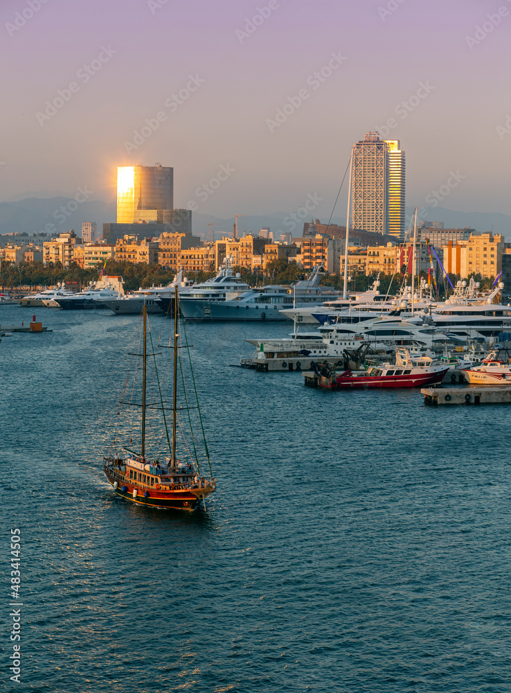 sailboat leaving the port of Barcelona at sunset sailboat leaving the port of Barcelona at sunset