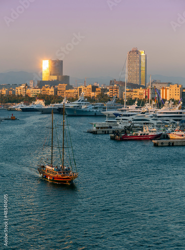 sailboat leaving the port of Barcelona at sunset