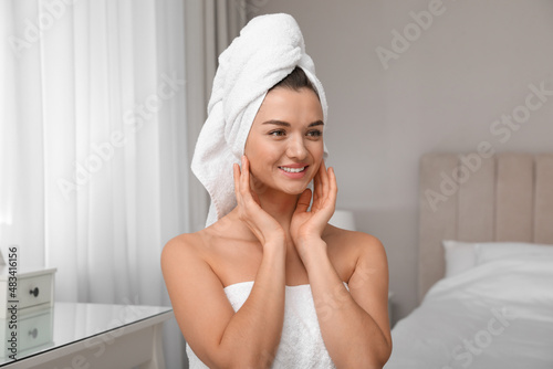 Beautiful young woman with hair wrapped in towel at home