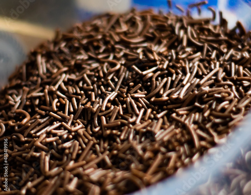 Chocolate sprinkles background ( chocolate granulado ), sweet food, candy. Ingredient used to make brigadeiro cake, pot cake and chocolate sweets. Selective focus, Close up
