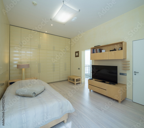 Modern scandic interior in beige tones of bedroom in luxury apartment.