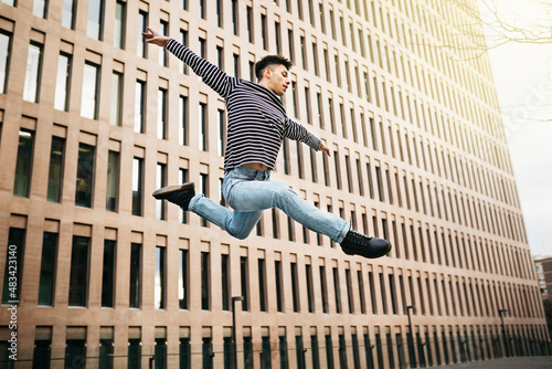 Young man jumping and dancing on the street
