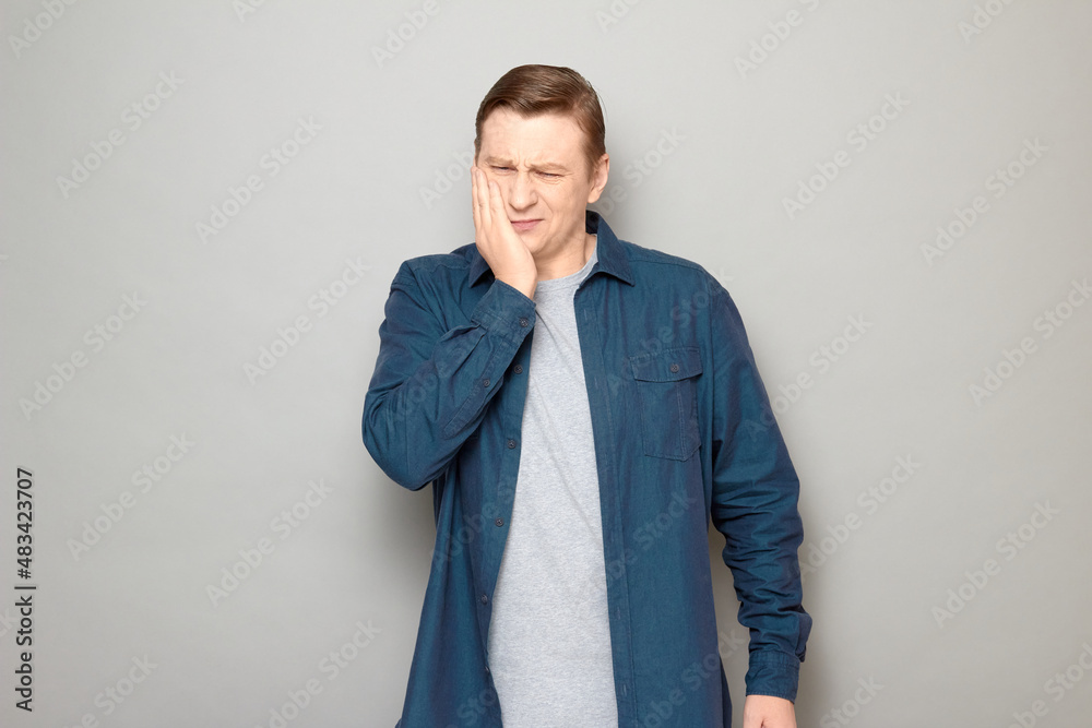 Portrait of unhappy man touching cheek and suffering from toothache Portrait of unhappy man touching cheek and suffering from toothache