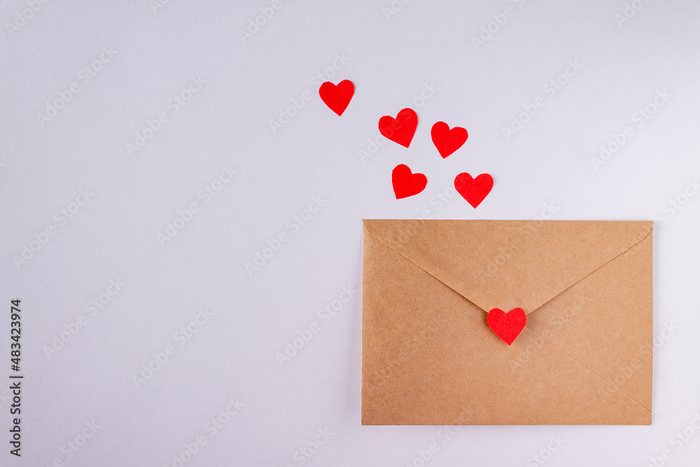 craft envelopes with red paper hearts on white background, copy space