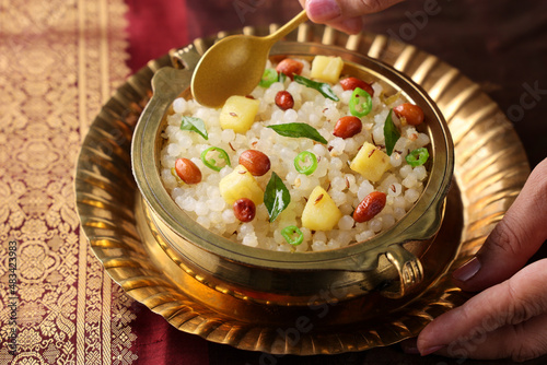 Sabudana Khichdi Sabudana khichri tapioca pearls cassava sago Khichdi Mahashivratri Shivratri Navratri Ram Navami festival fasting food sabudana usal woman hand serving vegetarian Indian food snack photo