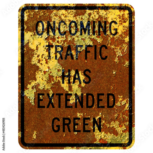 Old rusty American road sign - Oncoming traffic has extended green