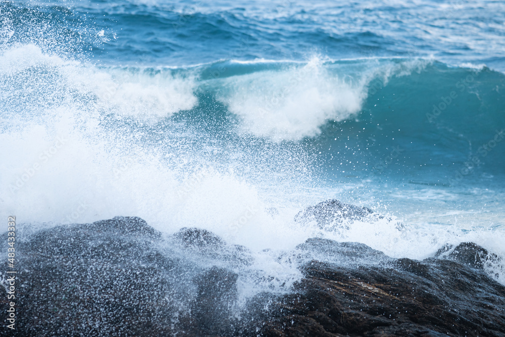 Fototapeta premium Man walking on a cloudy day on a beach with churning water