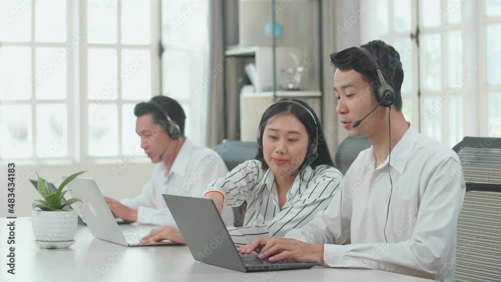 A Woman Of Three Asian Call Center Agents Wearing Headset And Helping A Man To Work With Computer While One Of Her Colleagues Are Speaking And Typing During The Call With Customer At The Office
A Woman Of Three Asian Call Center Agents Wearing Headset And Helping A Man To Work With Computer While One Of Her Colleagues Are Speaking And Typing During The Call With Customer At The Office