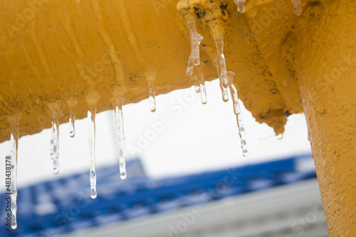 hanging icicles on a yellow gas pipe 