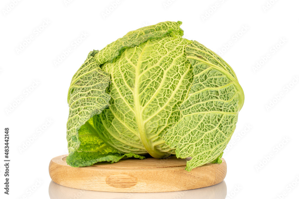 Fototapeta premium One cabbage of organic Savoy cabbage on a wooden tray, macro, isolated on white.