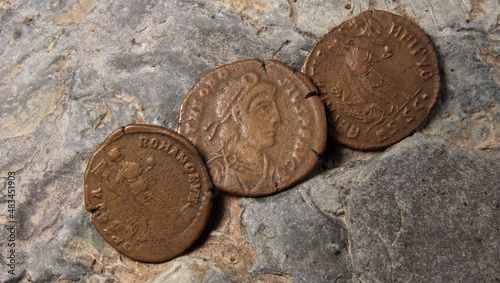 Old copper coins of the Roman Empire on the background of a large stone			