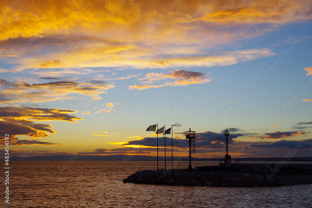 Sunrise in the port of Termoli, you can see the silhouette of lighthouses and flags blowing in the wind - Molise, Adriatic Sea