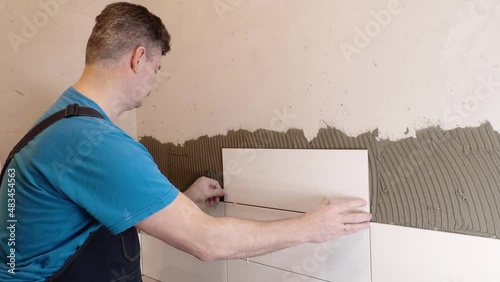  Tile maker performs the work of laying tiles on the wall of the bathroom. Tile works