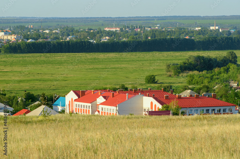 City buildings against the background of a green field City buildings against the background of a green field