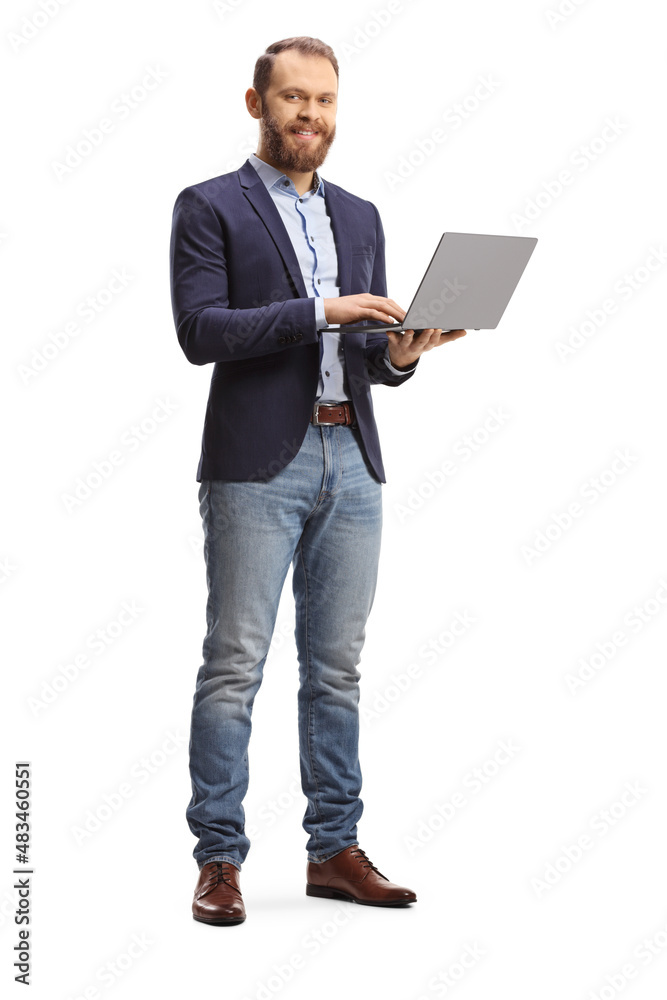 Man in a suit and jeans holding an open laptop computer Man in a suit and jeans holding an open laptop computer