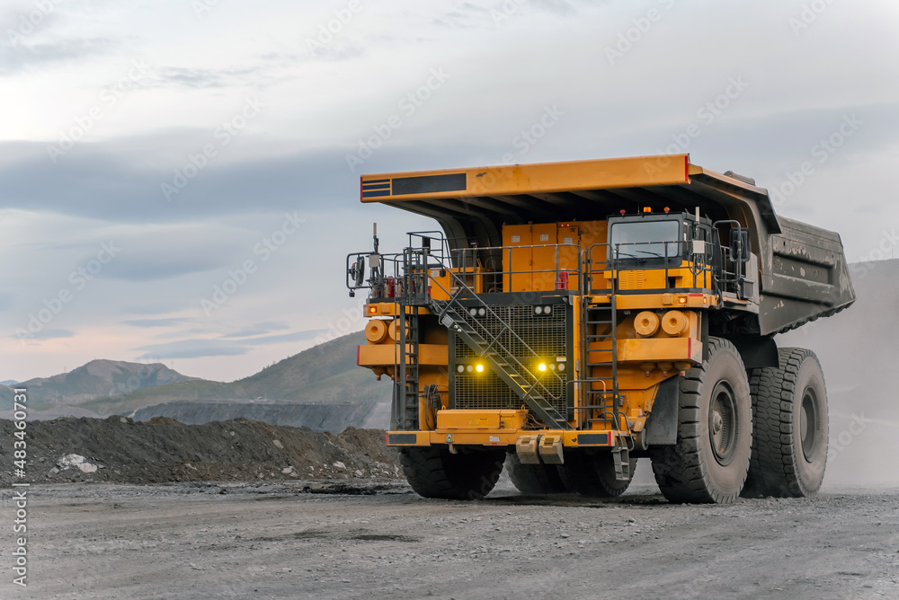 A dump truck drives through an open pit. A dump truck drives through an open pit.