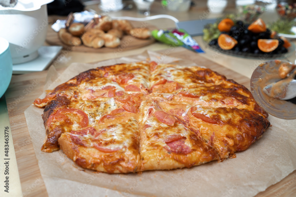 Pepperoni pizza with pizza sauce, mozzarella cheese and pepperoni. Pizza on on baking paper.