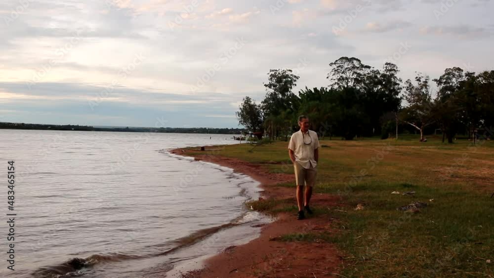Mature Man walking along Lago Paranoa at Parque das Garcas in Lago Norte Brasilia, Brazil