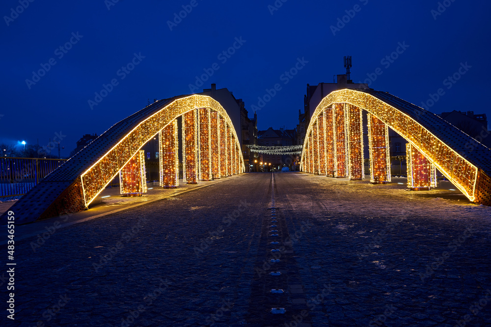 Fototapeta premium Christmas decorations on the steel structure of the bridge at night