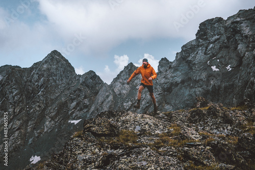 Running man in rocky mountains travel alone hiking adventure active extreme vacations outdoor healthy lifestyle motivation