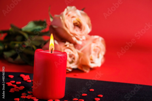 A burning red candle and a roses. Valentine s Day concept.