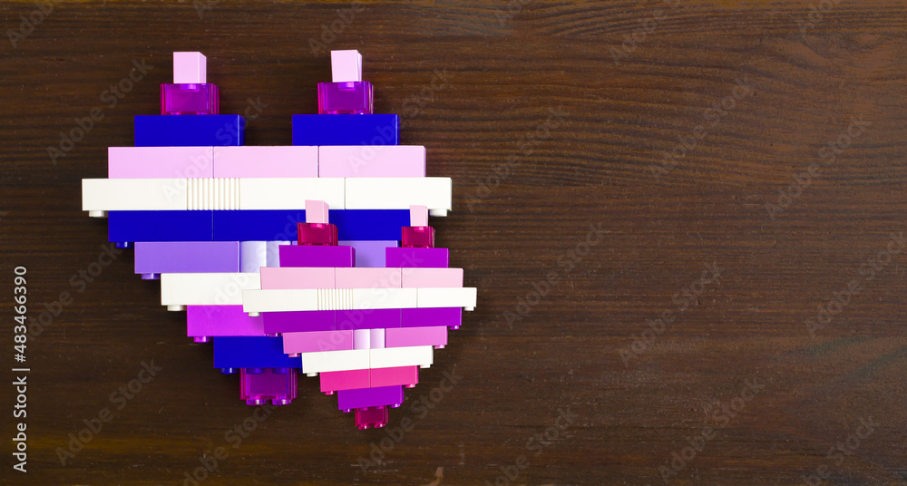 Obraz premium Bricks in the shape of a heart on a wooden background with copy space. Conceptual photo for valentine's day