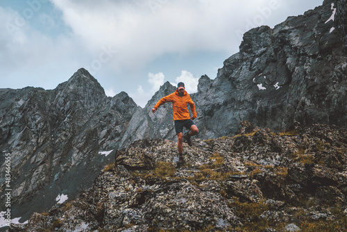 Man trail running alone hiking in mountains travel climbing adventure active extreme vacations outdoor healthy lifestyle freedom concept