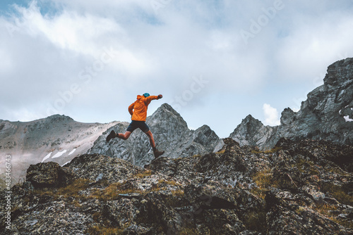 Man trail running in rocky mountains travel hiking adventure activity outdoor summer vacations healthy lifestyle skyrunning extreme sport concept photo