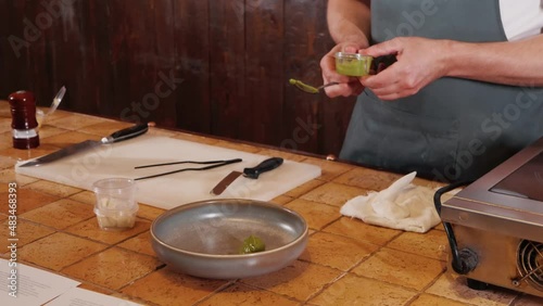 The chef on the stream prepares a dish of fried fish with broccoli and sauce