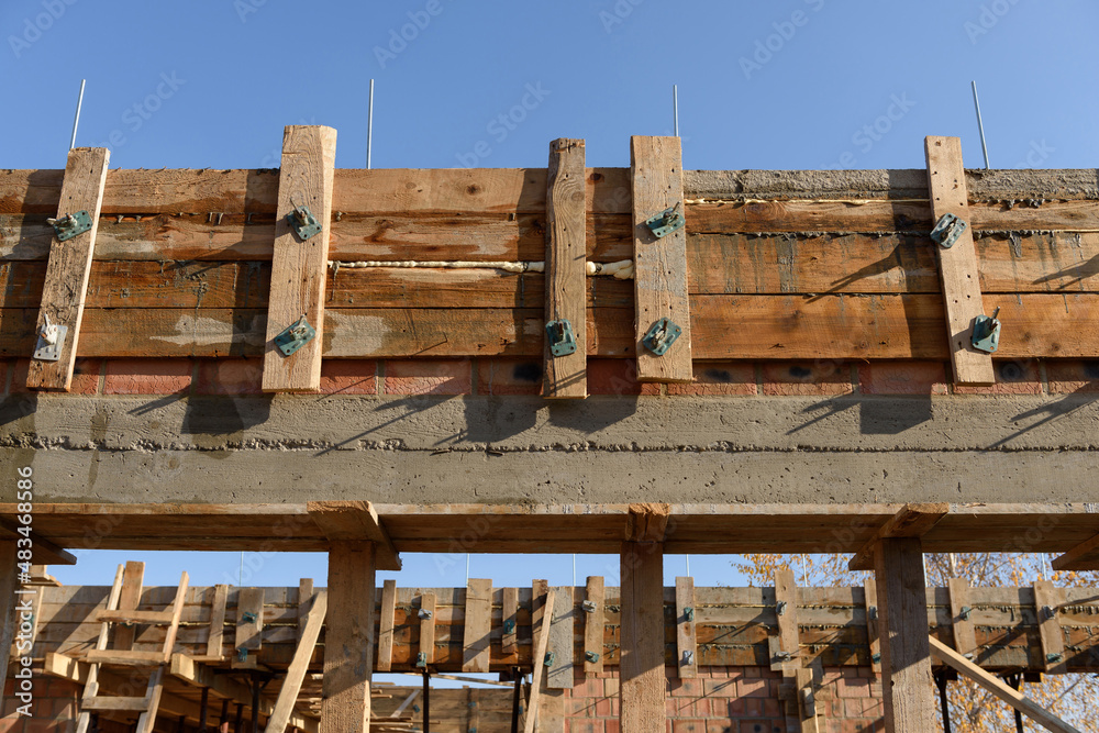 Brick house under construction. Elements of wooden formwork for pouring ...
