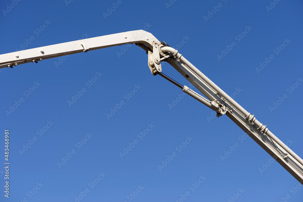 Truck mounted сoncrete pump and concrete mixer at a construction site. Concrete pouring process.
Element of unfolded hydraulic boom machine on blue sky background. Construction work concept. Truck mounted сoncrete pump and concrete mixer at a construction site. Concrete pouring process.
Element of unfolded hydraulic boom machine on blue sky background. Construction work concept.