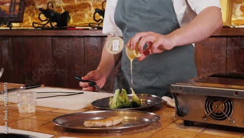 The chef on the stream prepares a dish of fried fish with broccoli and sauce