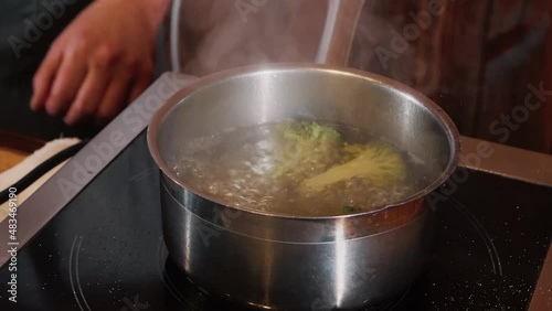 The chef on the stream prepares a dish of fried fish with broccoli and sauce