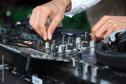 Disc jockey playing music for people at party outdoors - Dj at music live event - Live event, music and fun concept - Entertainment and party concept - Focus on hands