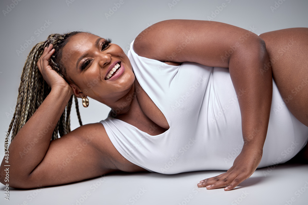 excited plus size lady posing in white sexy bodysuit lingerie, on