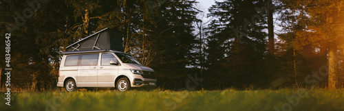 Fotografie Modern Camping Van parking at the forest in beautiful, authentic nature