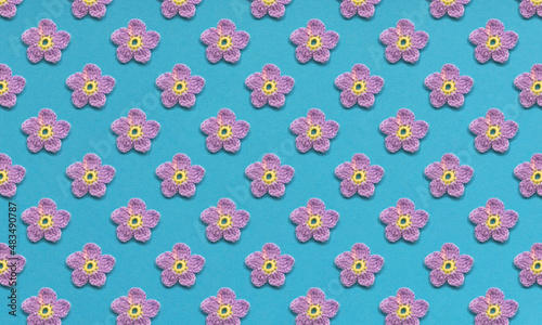 Pattern of purple flowers and one butterfly. Blue or turquoise background