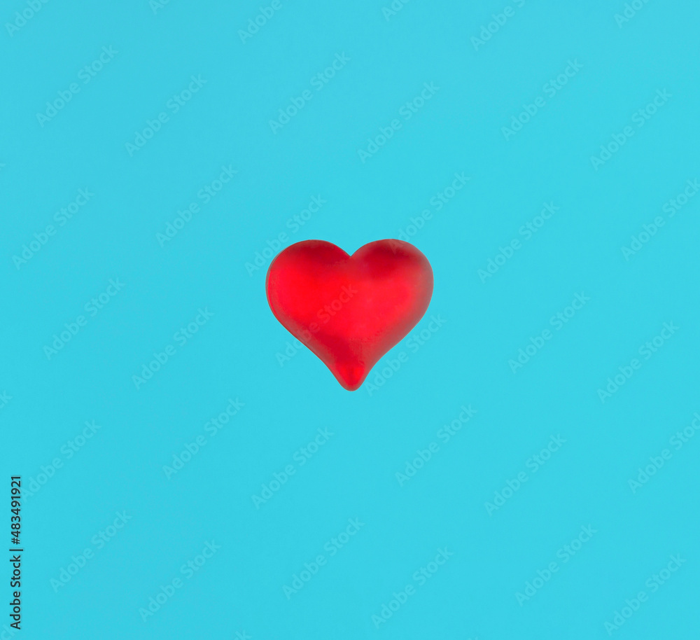 Minimal love concept with a red heart on blue background. Creative idea with red and turquoise blue colors.