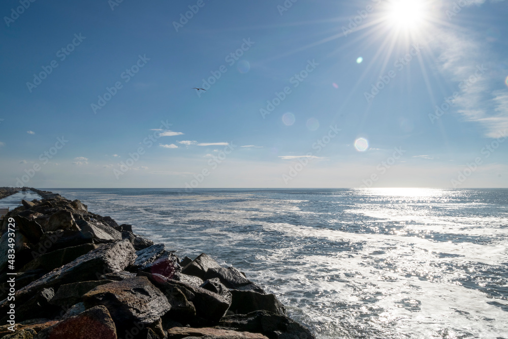 Ocean Sun rays, beach landscape and rocks