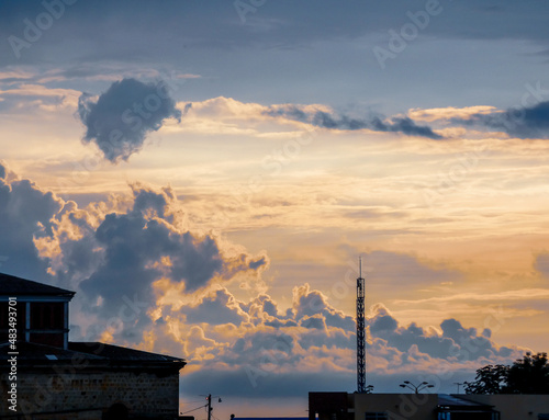 Cielo de atardecer con colores brillantes visto sobre las construcciones antiguas de un pueblo.
