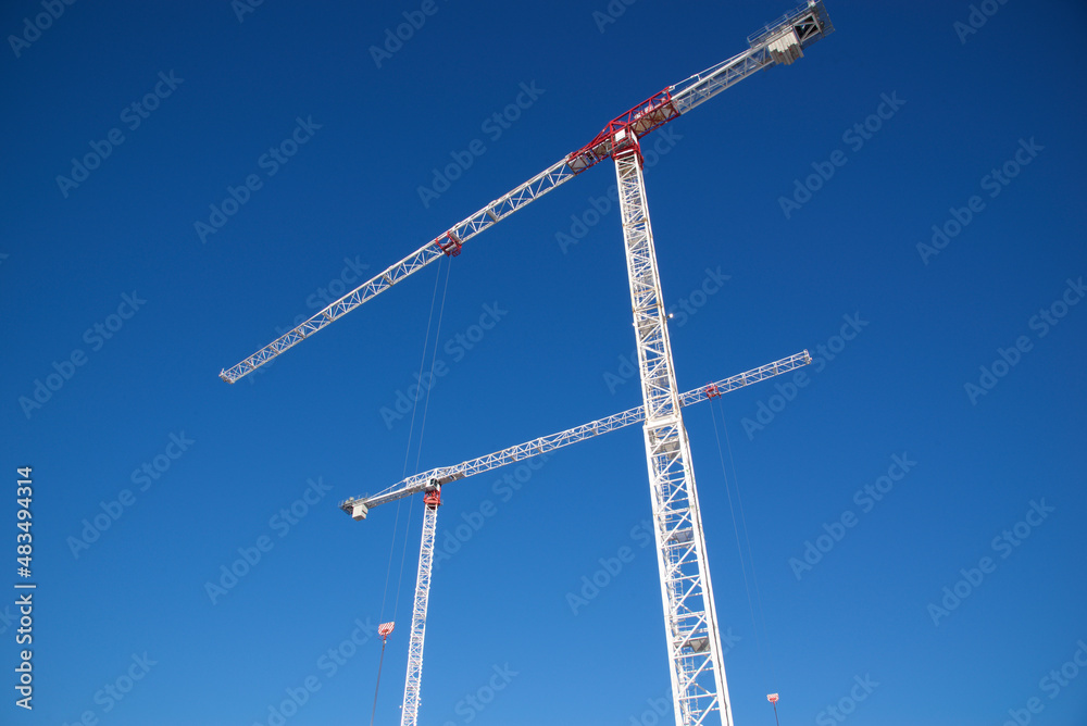 Construction crane in a construction site with blue sky background Construction crane in a construction site with blue sky background