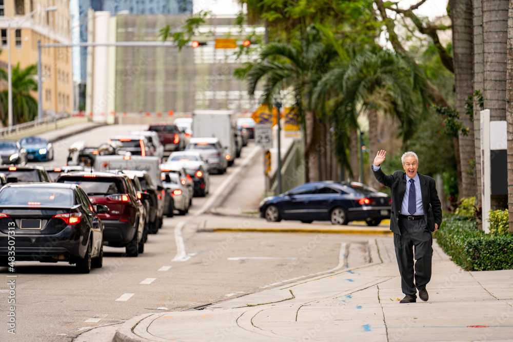 Old businessman waving and smiling from far Old businessman waving and smiling from far