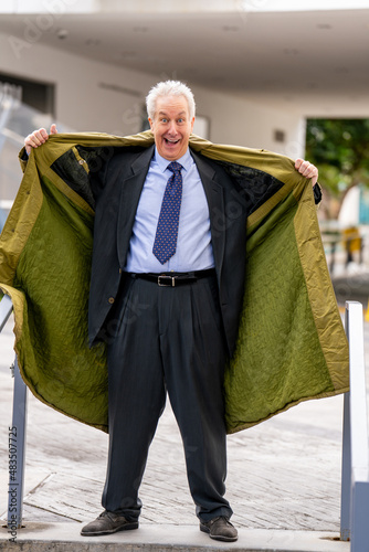 Businessman flashing open his trenchcoat to show his suit photo