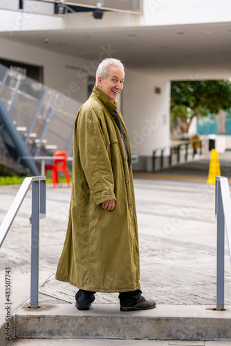 фотографія Old man posing in a green oversize trenchcoat