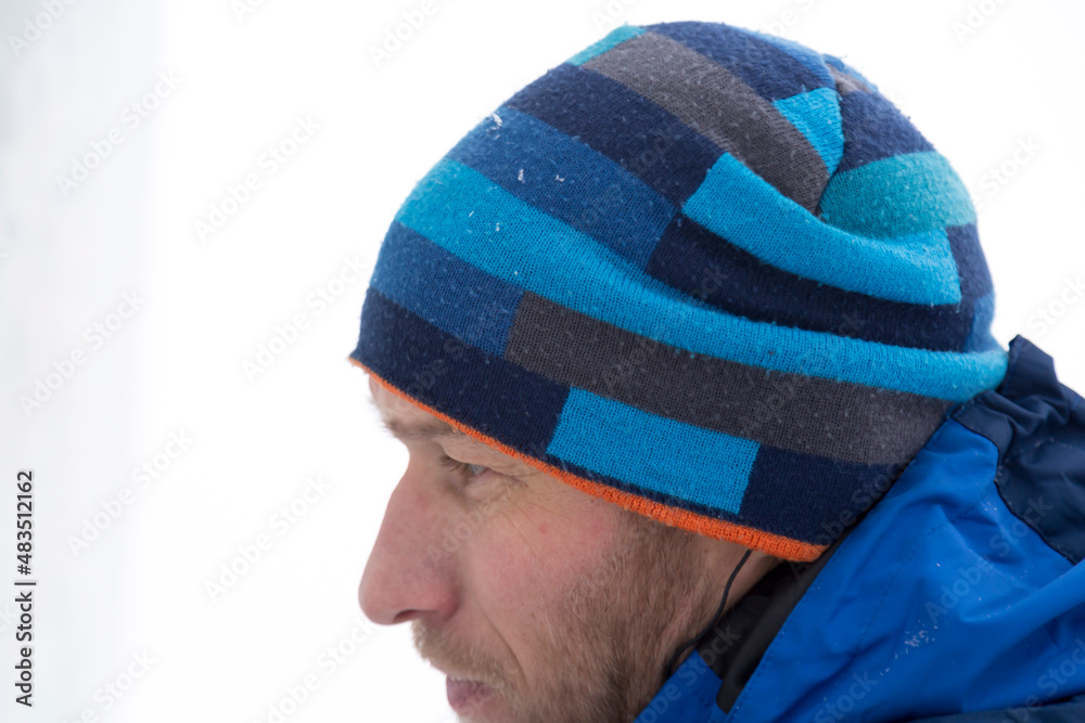 Portrait of a builder in a blue knitted hat and blue winter jacket Portrait of a builder in a blue knitted hat and blue winter jacket