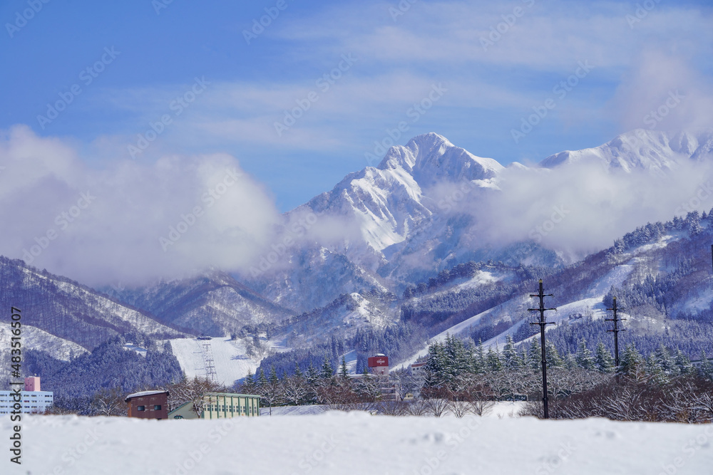 三角の頂上が美しい雪の大源太山とスキー場