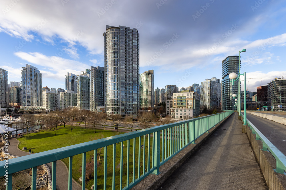 Pedestrian Sidewalk on Cambie Bridge in False Creek, Downtown Vancouver, British Columbia, Canada. Modern City on the Pacific Ocean Coast. Cityscape Skyline. Sunny winter day.